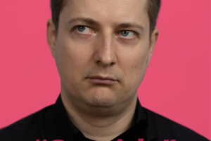 Plakāts ar komiķa Maksima Trivaškeviča portretu uz koši rozā fona. Vīrietis nopietni skatās uz augšu un pa kreisi. Plakāta teksts: Zilānu Tautas namā. "Smaids". Riktīgi pozitīva stand- up komēdija. Trešdien, 1. aprīlī 19.00. Komikis: Maksims Trivaškevičs. ieeja: 5,00 EUR.