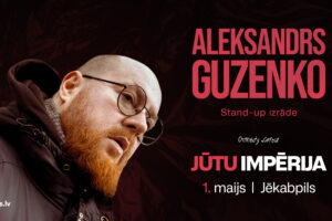 Plakāts ar Aleksandru Guzenko, vīrieti ar rudu bārdu, brillēm un plikpaurību, tērptu tumšā jakā, kurš skatās uz leju ar atvērtu muti. Plakāta teksts vēsta: "ALEKSANDRS GUZENKO Stand-up izrāde Comedy Latvia JŪTU IMPĒRIJA 1. maijs | Jēkabpils Pērc biļetes BezRindas.lv".