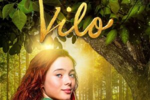 Filmas plakāts, kurā attēlota meitene ar gariem, rudiem matiem un zilām acīm, kas skatās uz priekšu, un blakus tai lapsa. Fonā – saulains mežs ar zaļiem kokiem un lapām. Plakāta augšpusē liels zelta uzraksts MEITENE VĀRDĀ VILO. Virs attēla teksts: KRUSTPILS KULTŪRAS CENTRĀ 24.aprīlī, plkst.18.30. Apakšā teksts par biļetēm: Biletes: iepriekšpārdošanā Jēkabpils TN kasē, 1h pirms kino - 24.aprīlī, biļetes varēs iegādāties Krustpils KC.